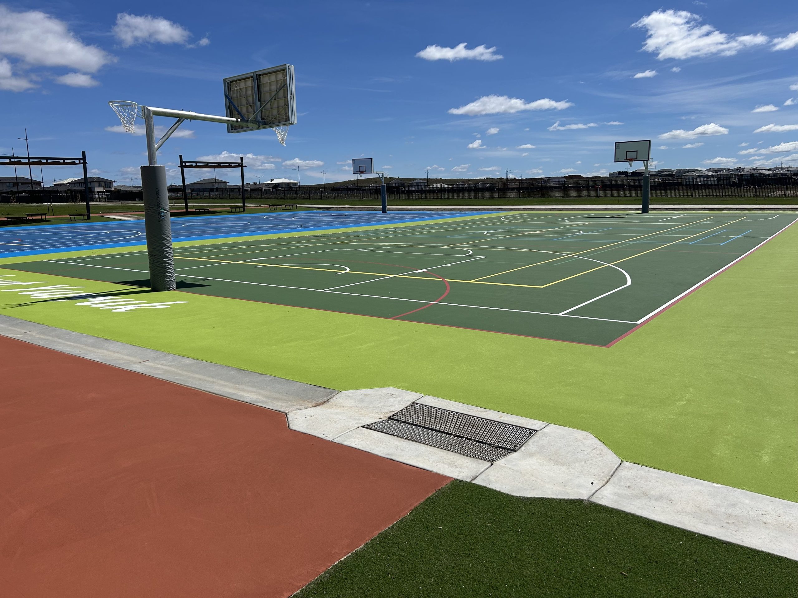 Outdoor basketball and netball courts under blue sky.
