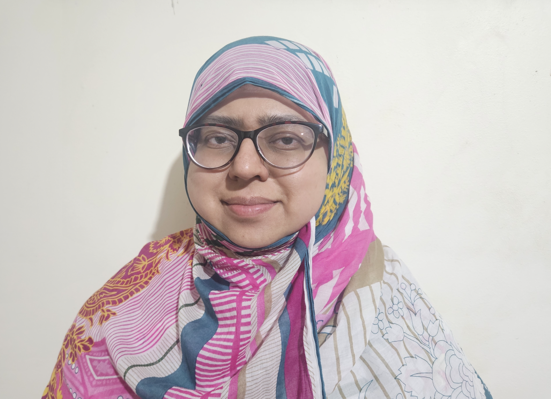 Person wearing colourful scarf and glasses.