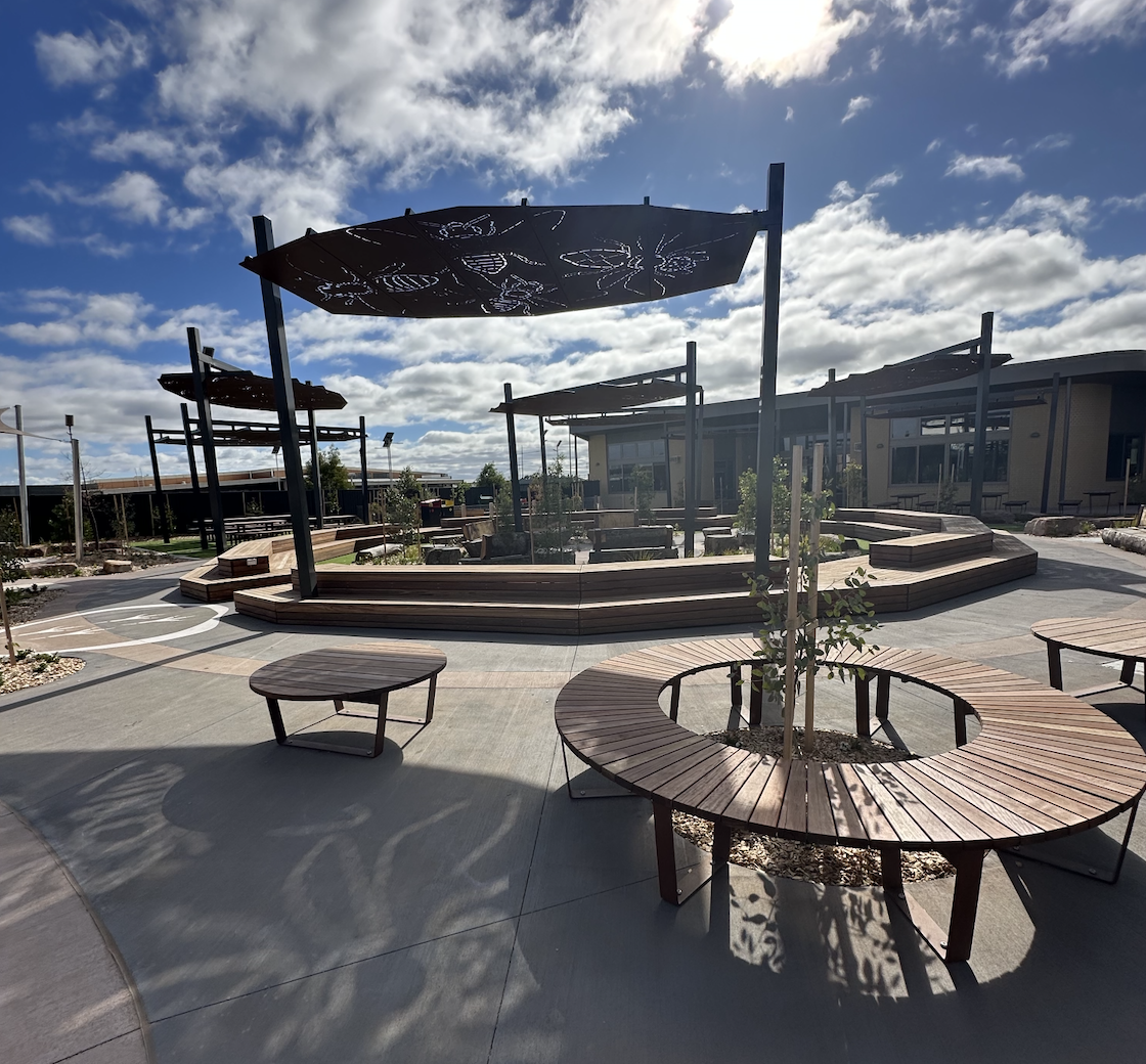 Modern outdoor seating area with shaded benches.