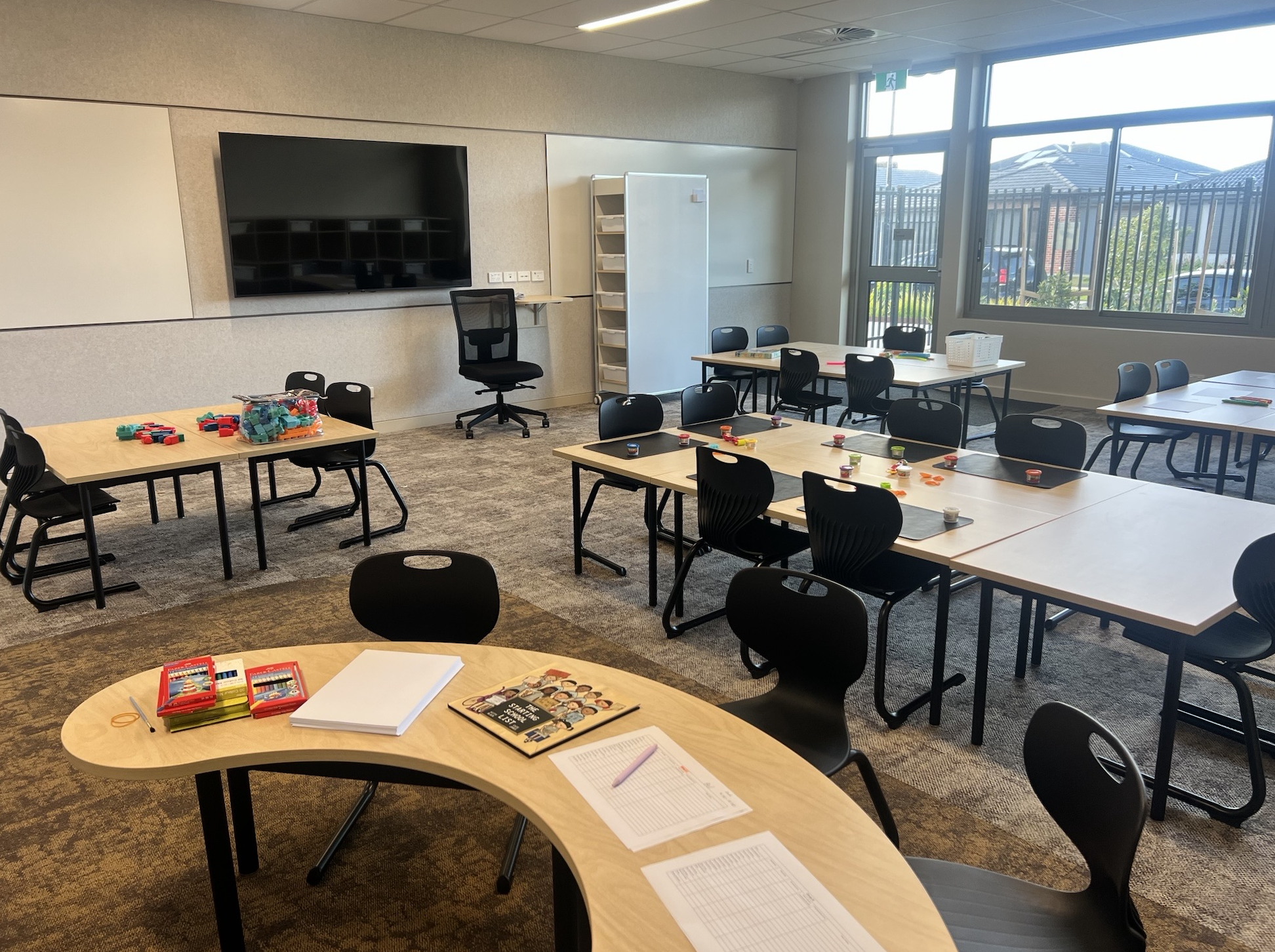Modern classroom with desks, chairs, and educational materials.