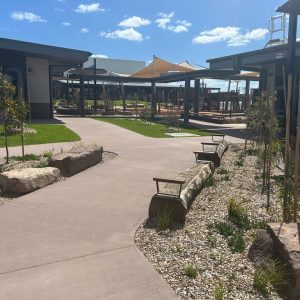 Modern landscaped school courtyard with seating and pathways.