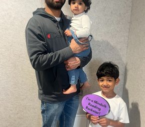 Family with child holding reading achievement sign.