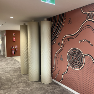 Corridor with pillars and Aboriginal artwork wall.